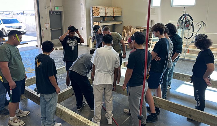 Abe from Austin Deck Company gathered by students at Glenn High School as he teaches how to frame a deck with YellaWood brand lumber.